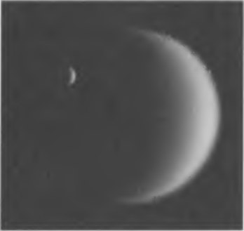 Рис. 8.16. Титан (справа) и Энцелад из системы Сатурна. Этот снимок довольно точно передает соотношение их размеров (10:1). Фото получено аппаратом «Кассини» 5 февраля 2006 г., когда расстояние от него до Энцелада составляло 4,1 млн км, а до Титана — 5,3 млн км